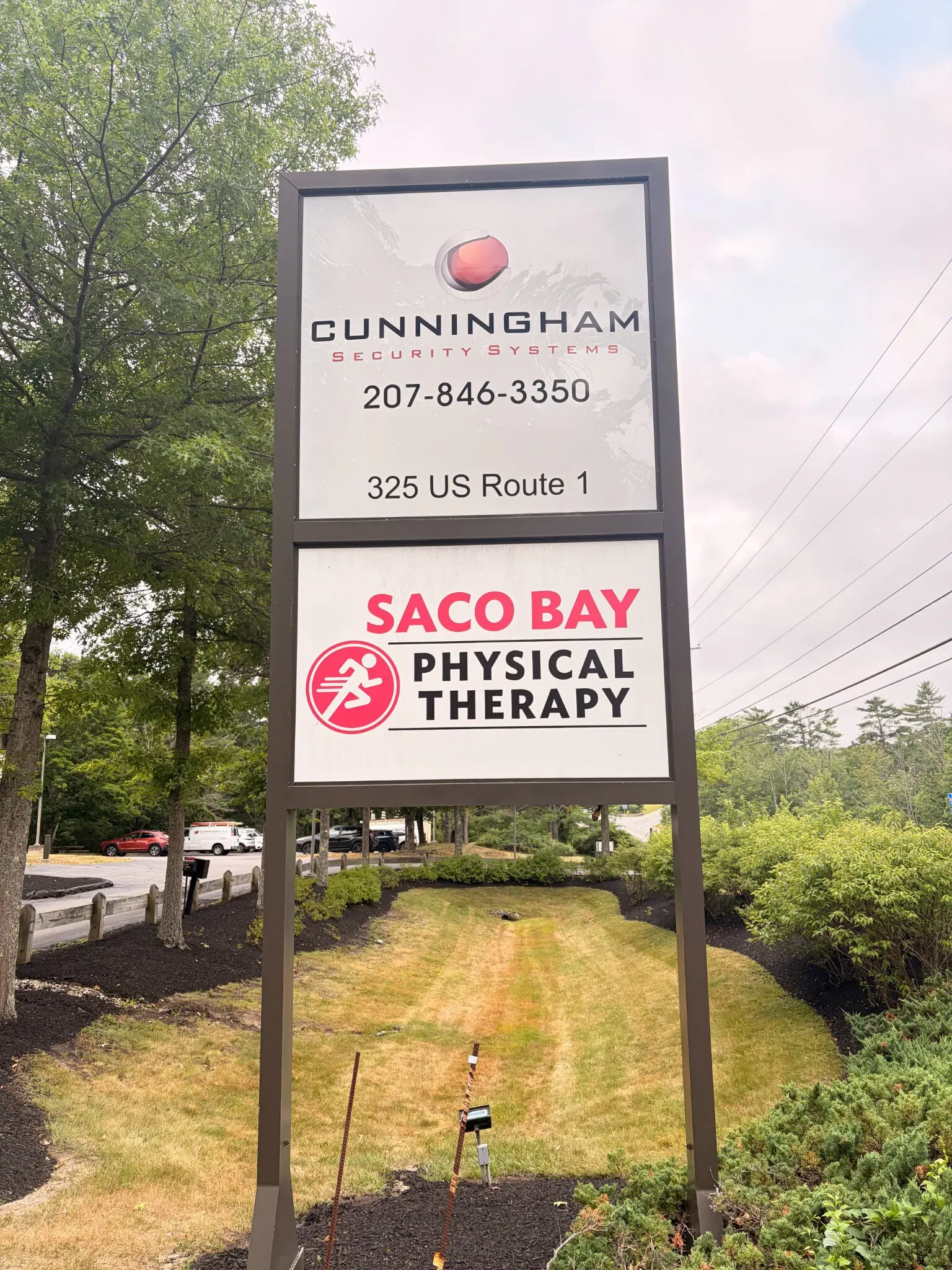 Roadside sign at 325 US Route 1 showing the Cunningham Security Systems logo and phone number above a Saco Bay Physical Therapy panel
