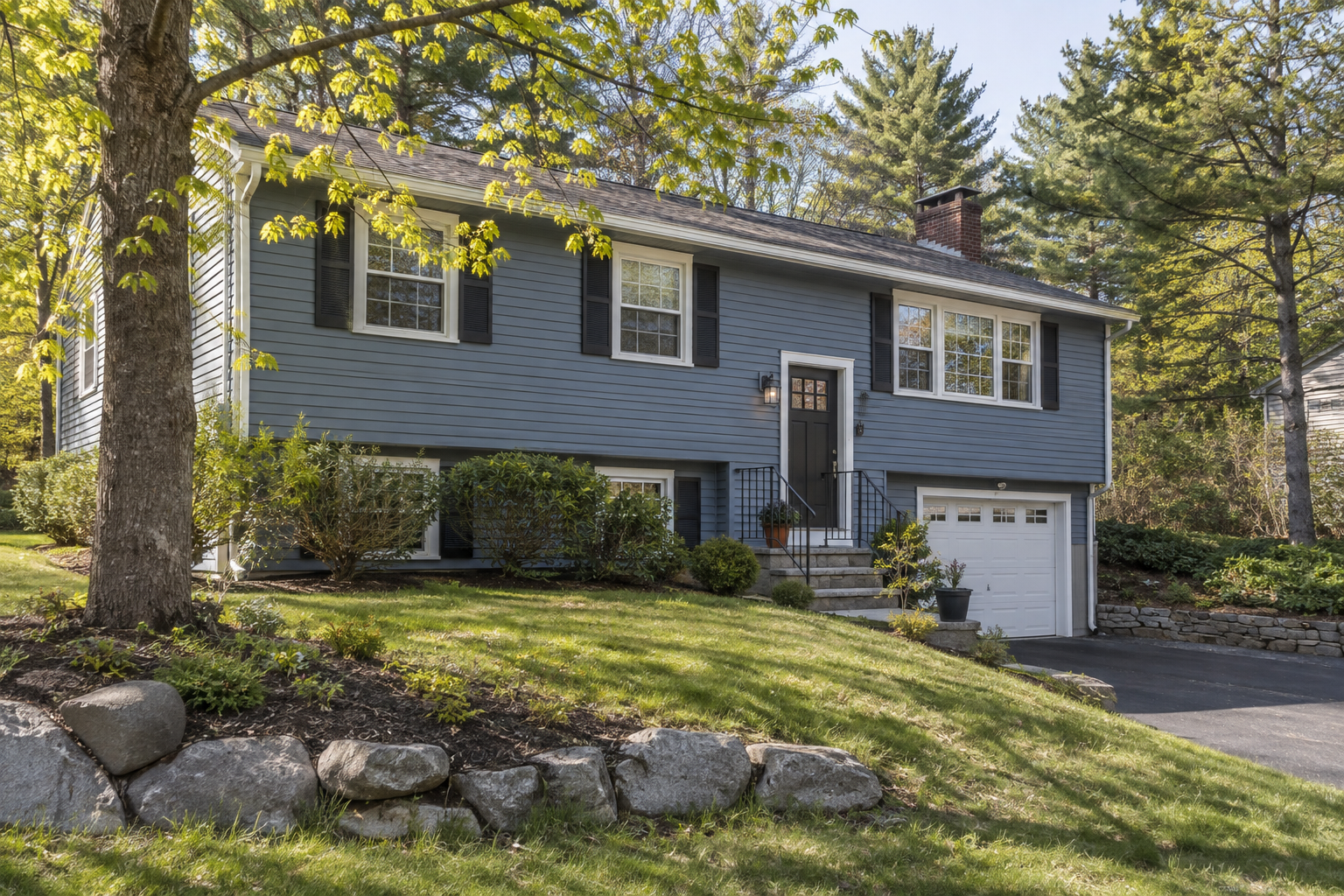 Split-entry home with a garage on a wooded New England lot