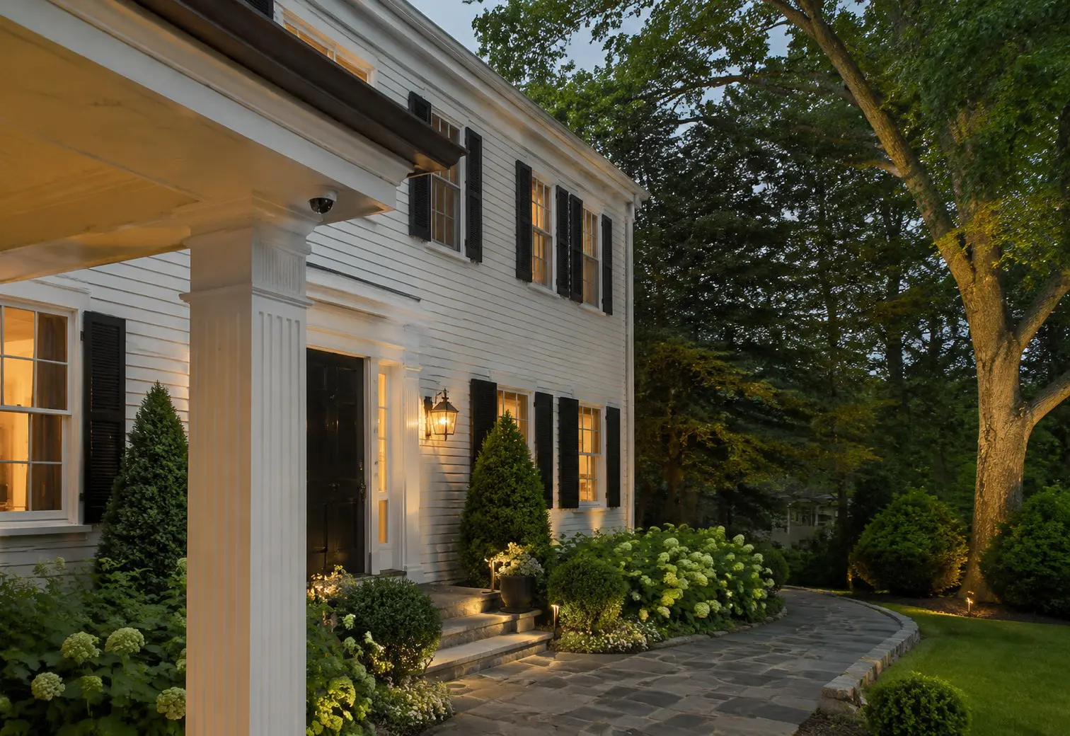 Discreet security camera beneath the porch of a traditional New England clapboard home